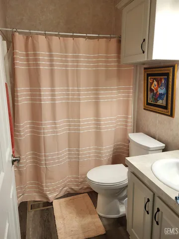 a bathroom with a toilet and a shower curtain