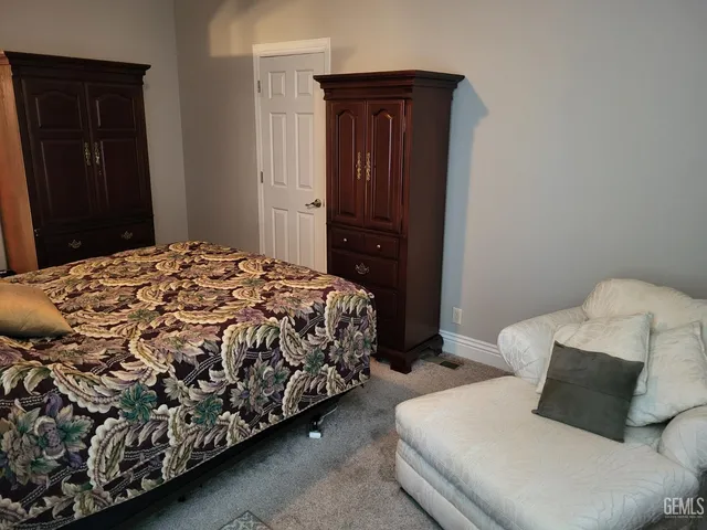 a bedroom with a bed and cabinet