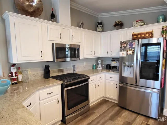a kitchen with stainless steel appliances white cabinets white stove a sink and a refrigerator