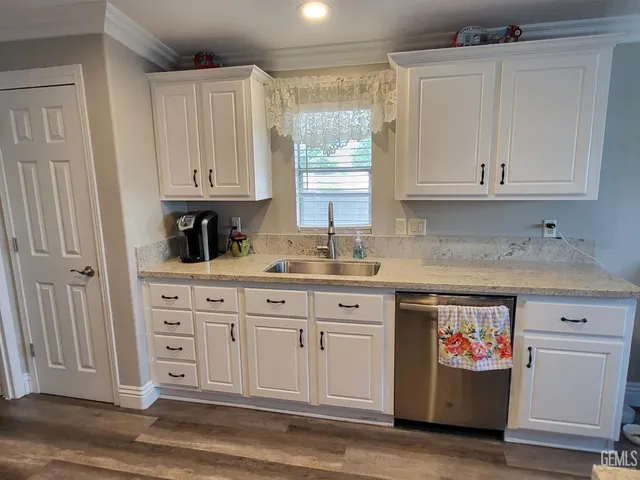 a kitchen with stainless steel appliances white cabinets and a window