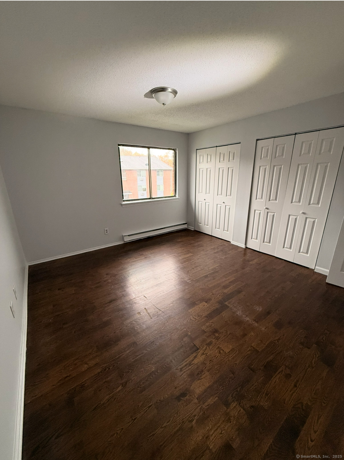 24 Coleman Street, Unit K West Haven, CT 06516 - Photo 3 of 6 an empty room with wooden floor and windows