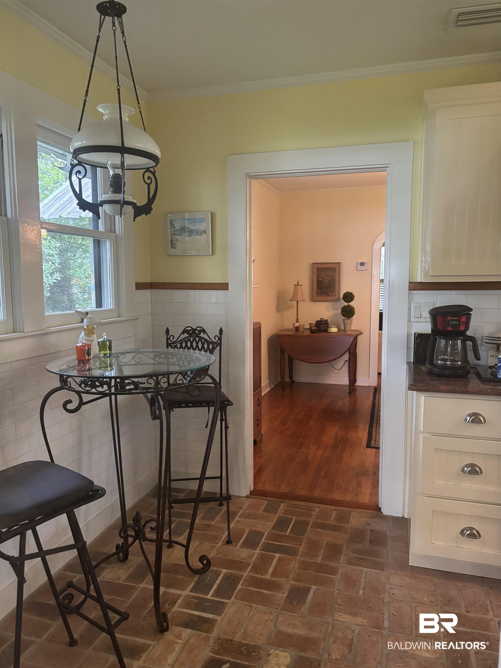 216 West Orange Avenue Foley, AL 36535 - Photo 16 of 37 Dining area featuring ornamental molding, brick floors, a wainscoted wall, and tile walls