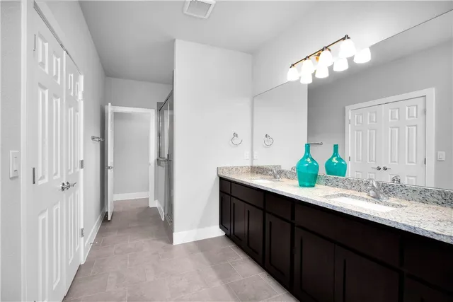 a bathroom with a double vanity sink and a mirror