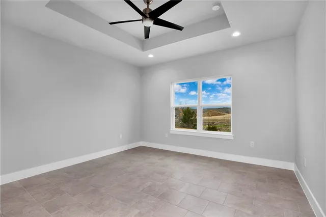 an empty room with a window and a fan