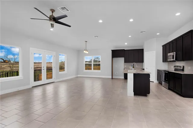 a view of kitchen with stainless steel appliances refrigerator stove microwave and cabinets