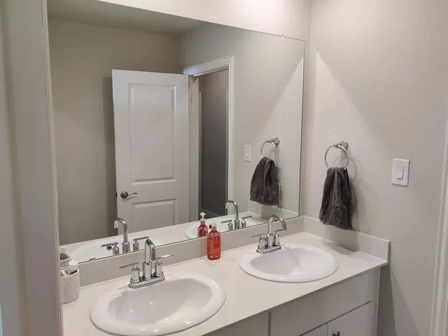 a bathroom with a sink and mirror with toilet