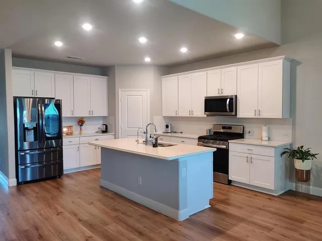 a kitchen with stainless steel appliances granite countertop a sink stove and refrigerator