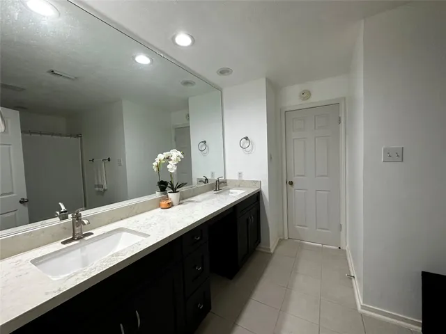 a bathroom with a granite countertop sink double vanity and a mirror