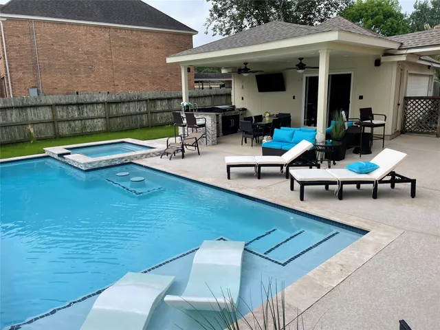 a view of a backyard with a patio and swimming pool