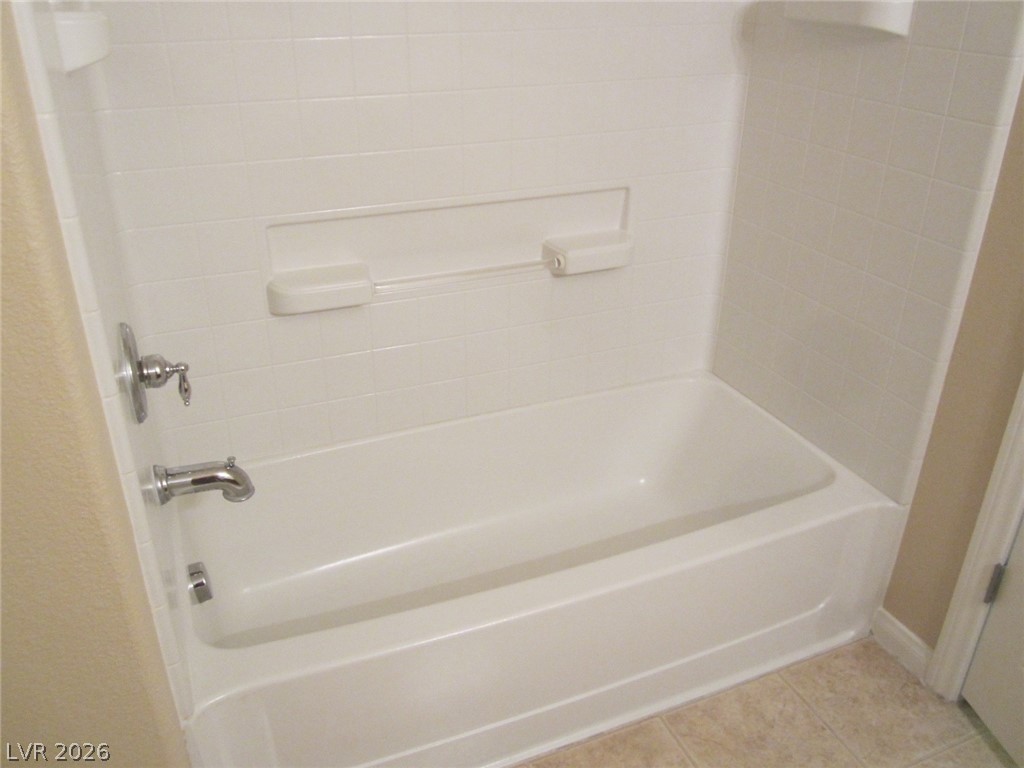 7701 West Robindale Road, Unit 262 Las Vegas, NV 89113 - Photo 17 of 26 A pristine white bathtub and shower combo offers a clean and inviting retreat.