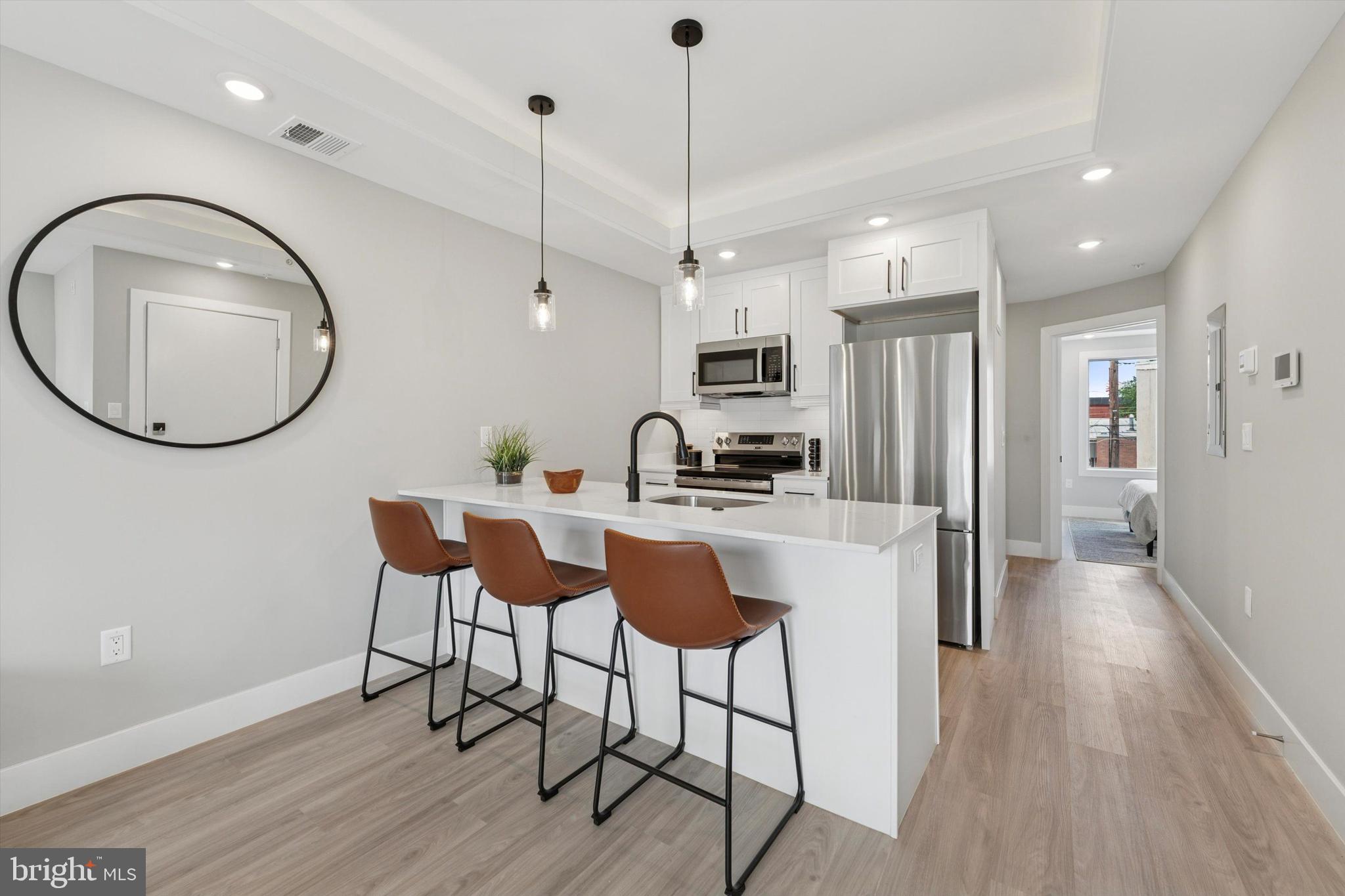 2401 North 2nd Street, Unit F3 Philadelphia, PA 19133 - Photo 25 of 26 a kitchen with kitchen island a dining table chairs and a wooden floor