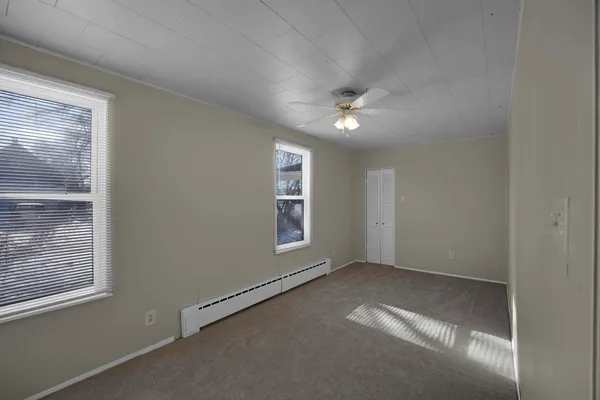 an empty room with windows and fan