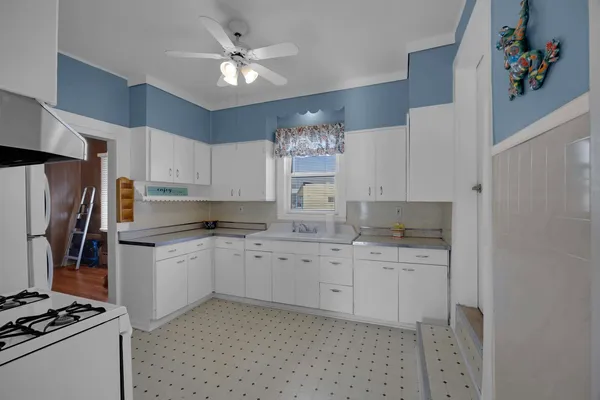 a kitchen with granite countertop a sink cabinets stainless steel appliances and a window