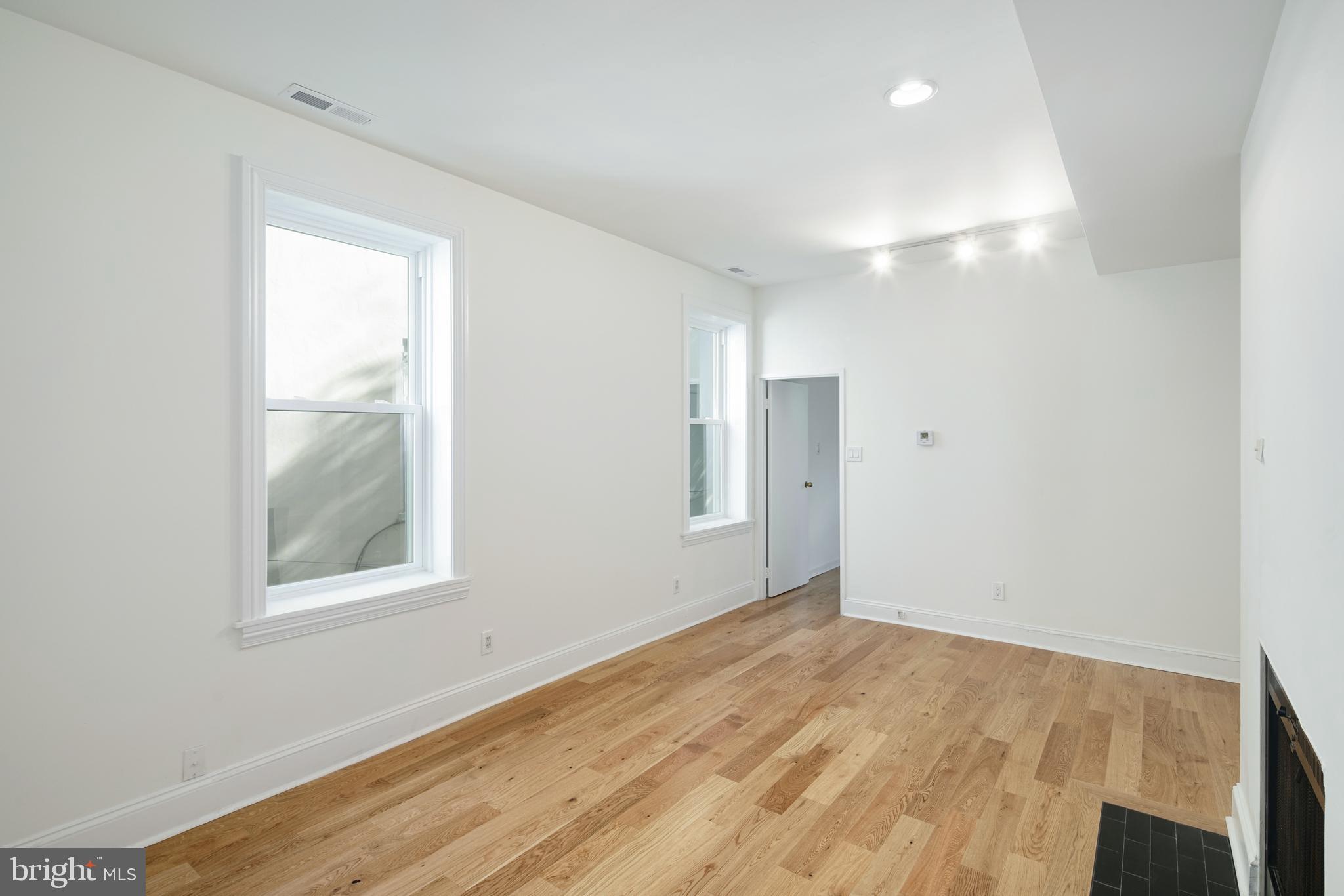 1716 Wallace Street, Unit 202 Philadelphia, PA 19130 - Photo 4 of 12 a view of an empty room with wooden floor and a window