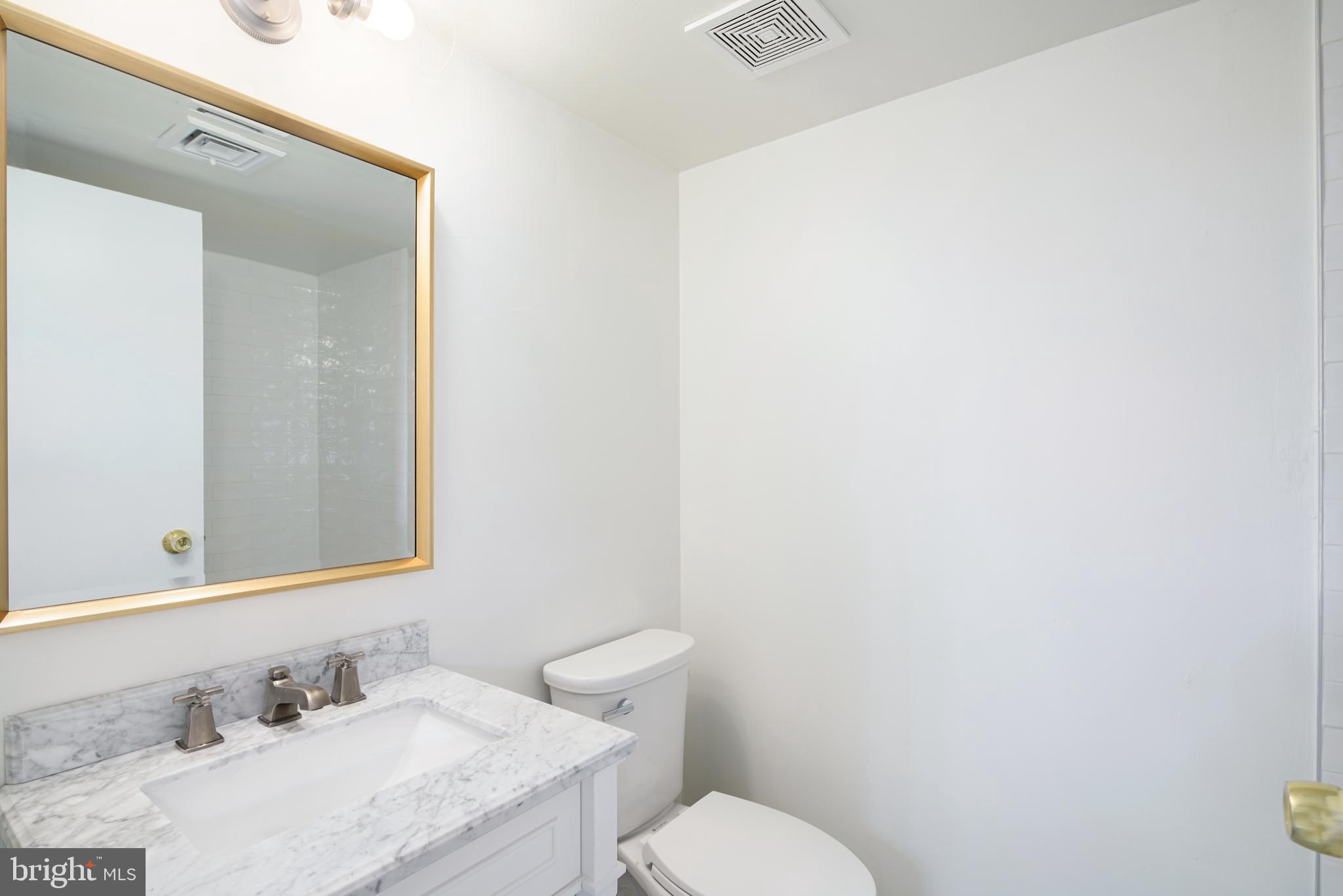 1716 Wallace Street, Unit 202 Philadelphia, PA 19130 - Photo 7 of 12 a bathroom with a granite countertop sink and a mirror
