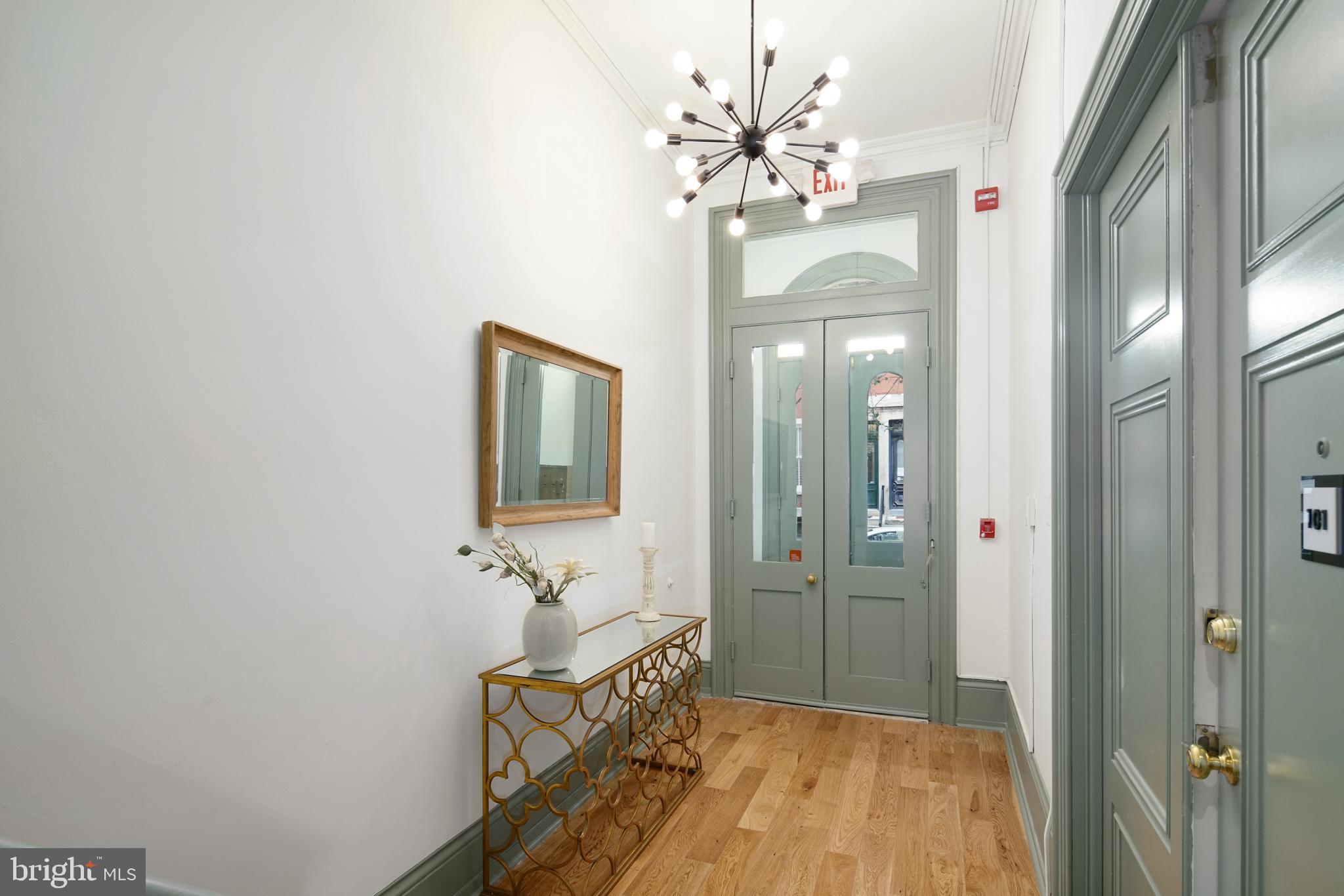 1716 Wallace Street, Unit 202 Philadelphia, PA 19130 - Photo 8 of 12 a view of a hallway with chandelier and wooden floor