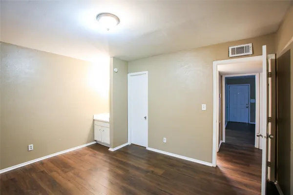 an empty room with wooden floor and closet