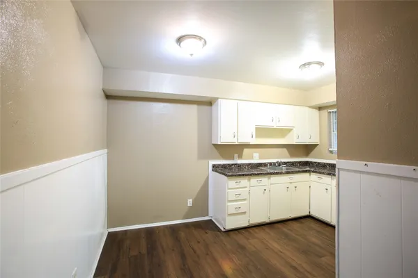 a kitchen with granite countertop a sink and a stove top oven