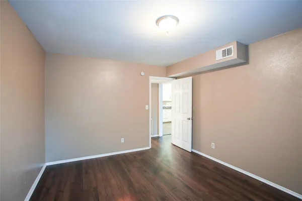 a view of an empty room and wooden floor