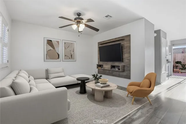 a living room with furniture a flat screen tv and a chandelier