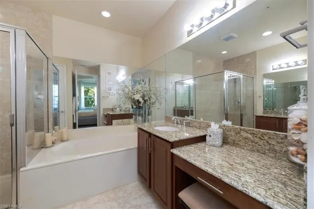 a bathroom with a granite countertop sink mirror and a bath tub