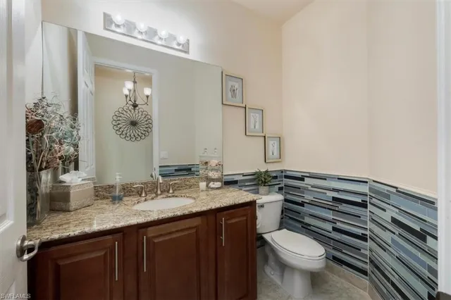 a bathroom with a granite countertop toilet sink and mirror