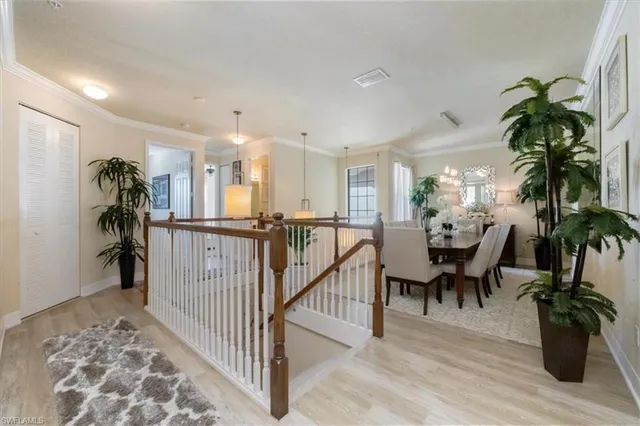 a view of a hallway with dining room and wooden floor