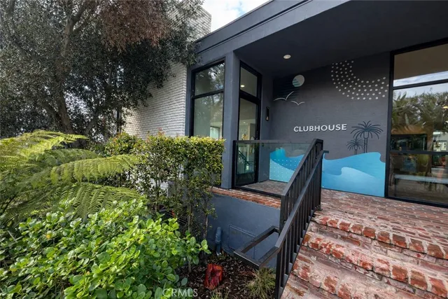 a view of a refrigerator in kitchen and an empty room with wooden floor