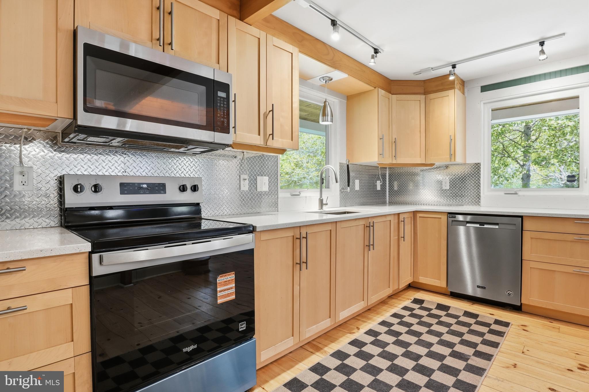293 Grove Road Delta, PA 17314 - Photo 6 of 36 a kitchen with stainless steel appliances a stove a microwave sink and cabinets