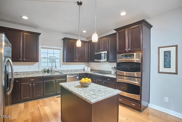 a kitchen with stainless steel appliances granite countertop a sink stove and microwave