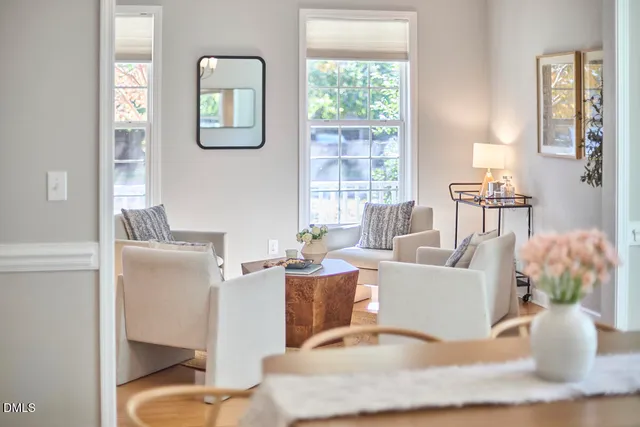 a dining room with wooden floor a chandelier a wooden table and chairs