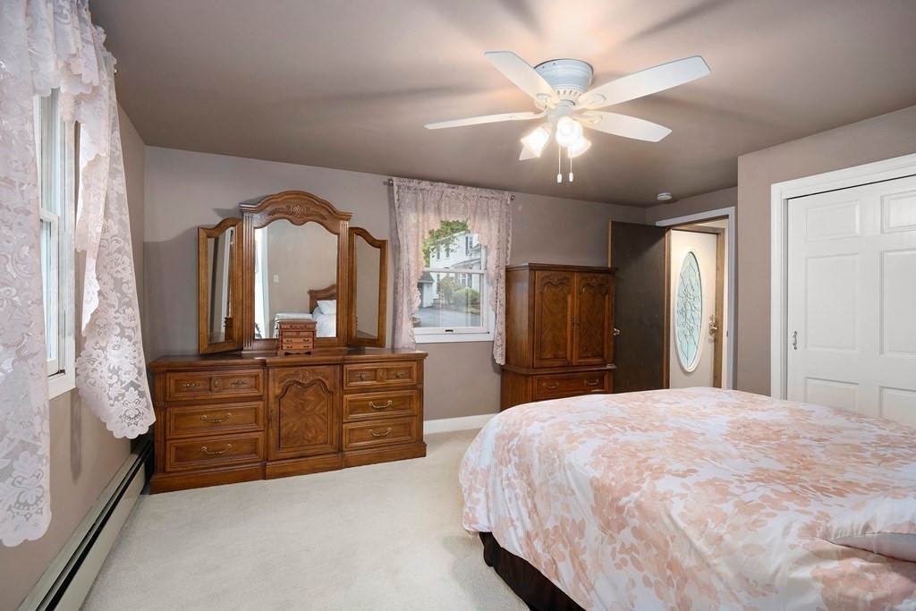 102 Orange Street Reading, MA 01867 - Photo 12 of 23 a bedroom with a large bed and a chandelier