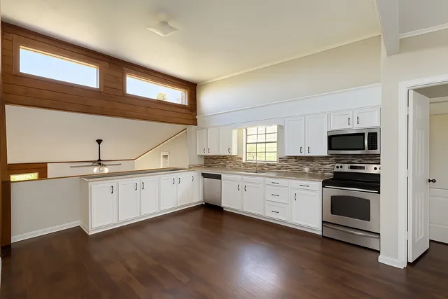 a kitchen with granite countertop white cabinets and white appliances