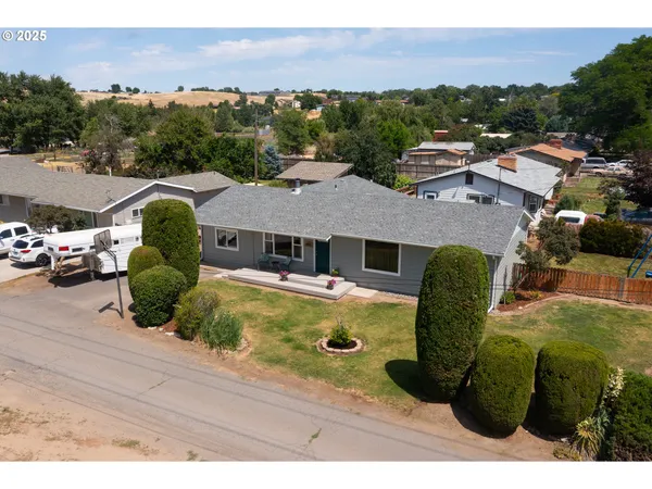 an aerial view of residential houses with outdoor space and parking