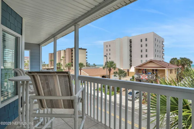 a living room with furniture floor to ceiling window hardwood floor and a flat screen tv