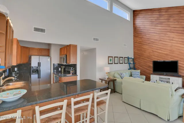 a dining room with furniture and large windows