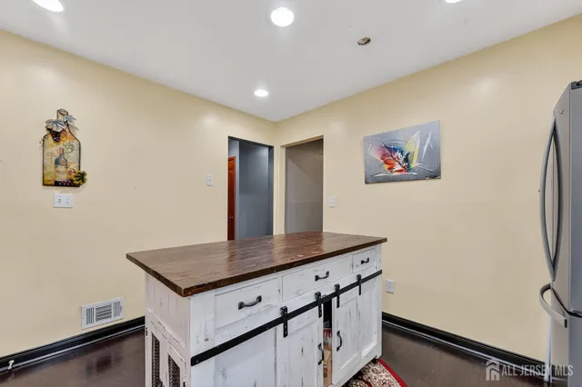 a view of kitchen island with refrigerator furniture and wooden floor