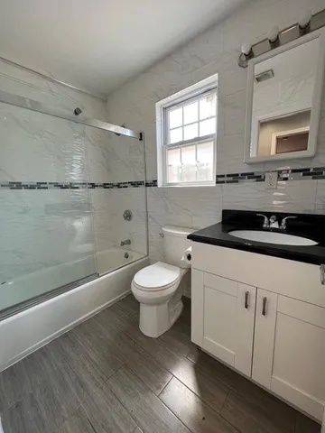 a bathroom with a toilet a sink and mirror