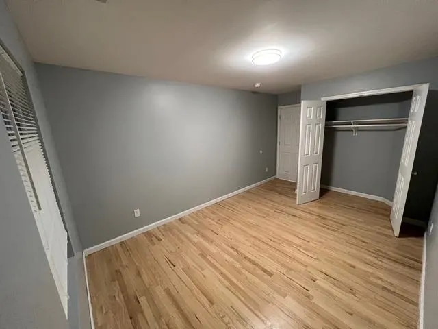 a view of empty room with wooden floor