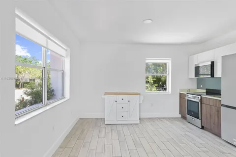 a kitchen with cabinets wooden floor and stainless steel appliances