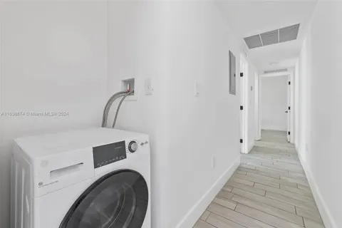 a view of a hallway with wooden floor and closet