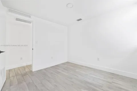 a bathroom with a sink a toilet a large mirror and a glass door shower