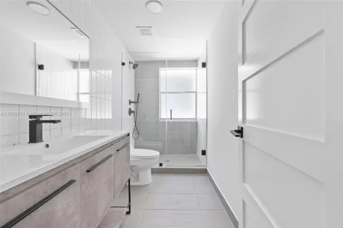 a bathroom with a shower sink vanity and toilet