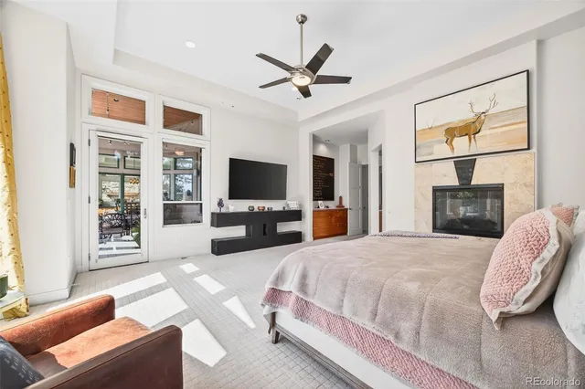 a spacious bedroom with a bed flat screen tv and a couch