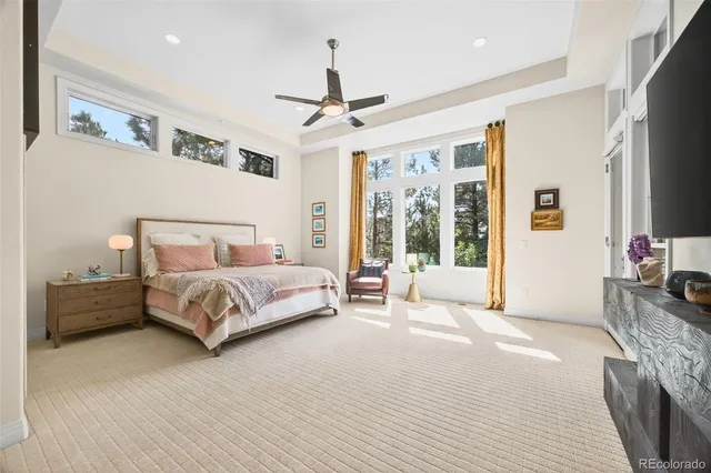 a bedroom with a large bed and a flat tv screen on dresser