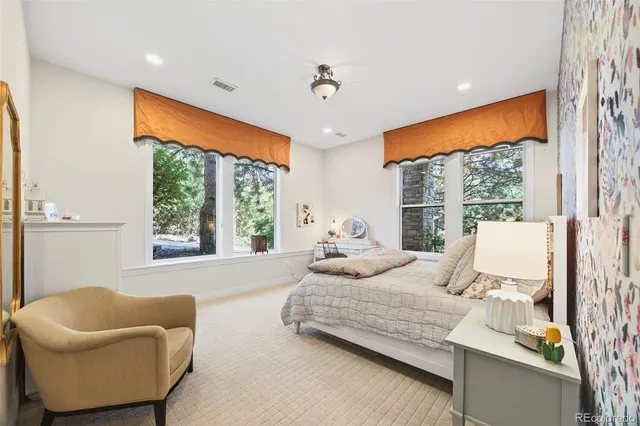 a spacious bedroom with a bed a couch and a window