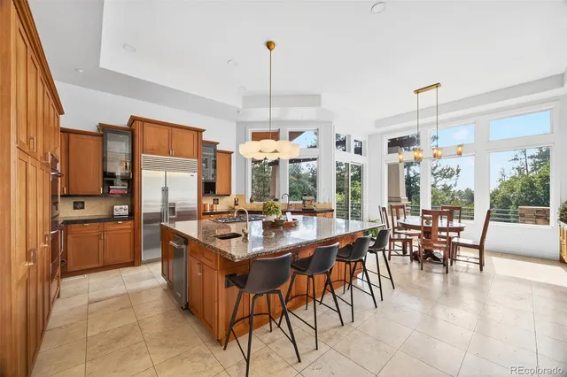 a large kitchen with a table chairs and refrigerator