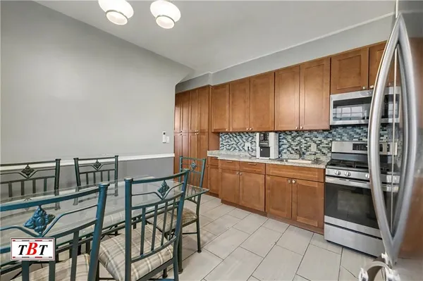 a kitchen with stainless steel appliances granite countertop a stove a sink and a refrigerator