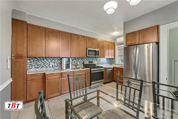 a kitchen with granite countertop a refrigerator stove top oven and sink