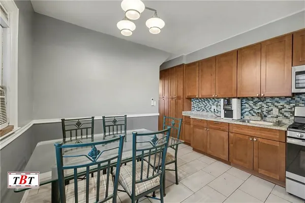 a kitchen with granite countertop a table chairs stove and cabinets